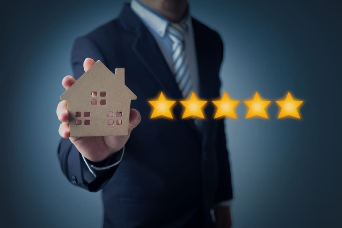 Five stars next to a wooden home, reputable property management Charleston concept