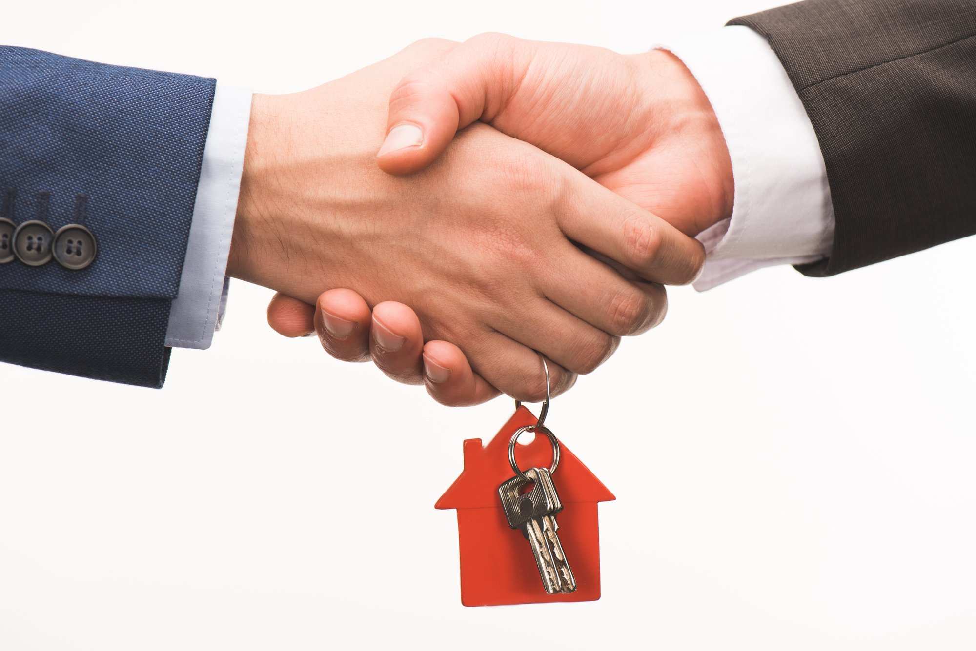 Cropped image of shaking hands with key from house isolated on white