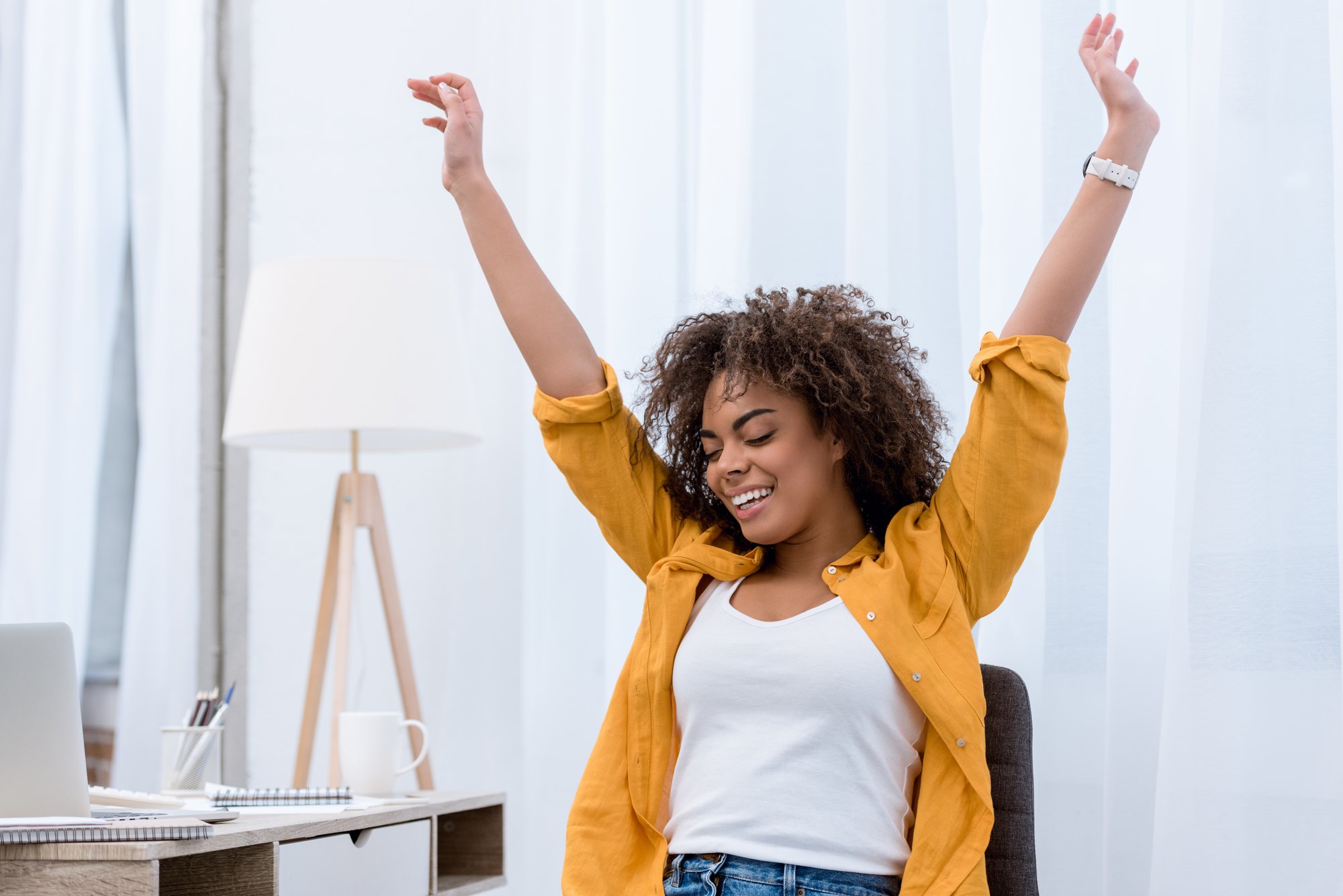 Happy young woman with raised hands