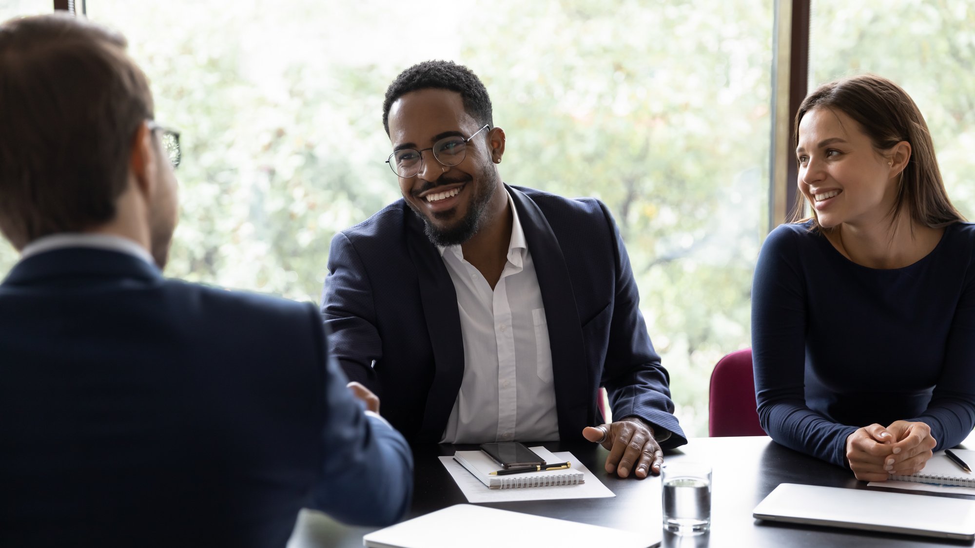 Smiling male colleagues shake hands get acquainted in office