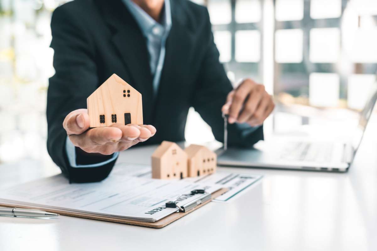 A man holds a house model, best property management companies Charleston, SC, concept