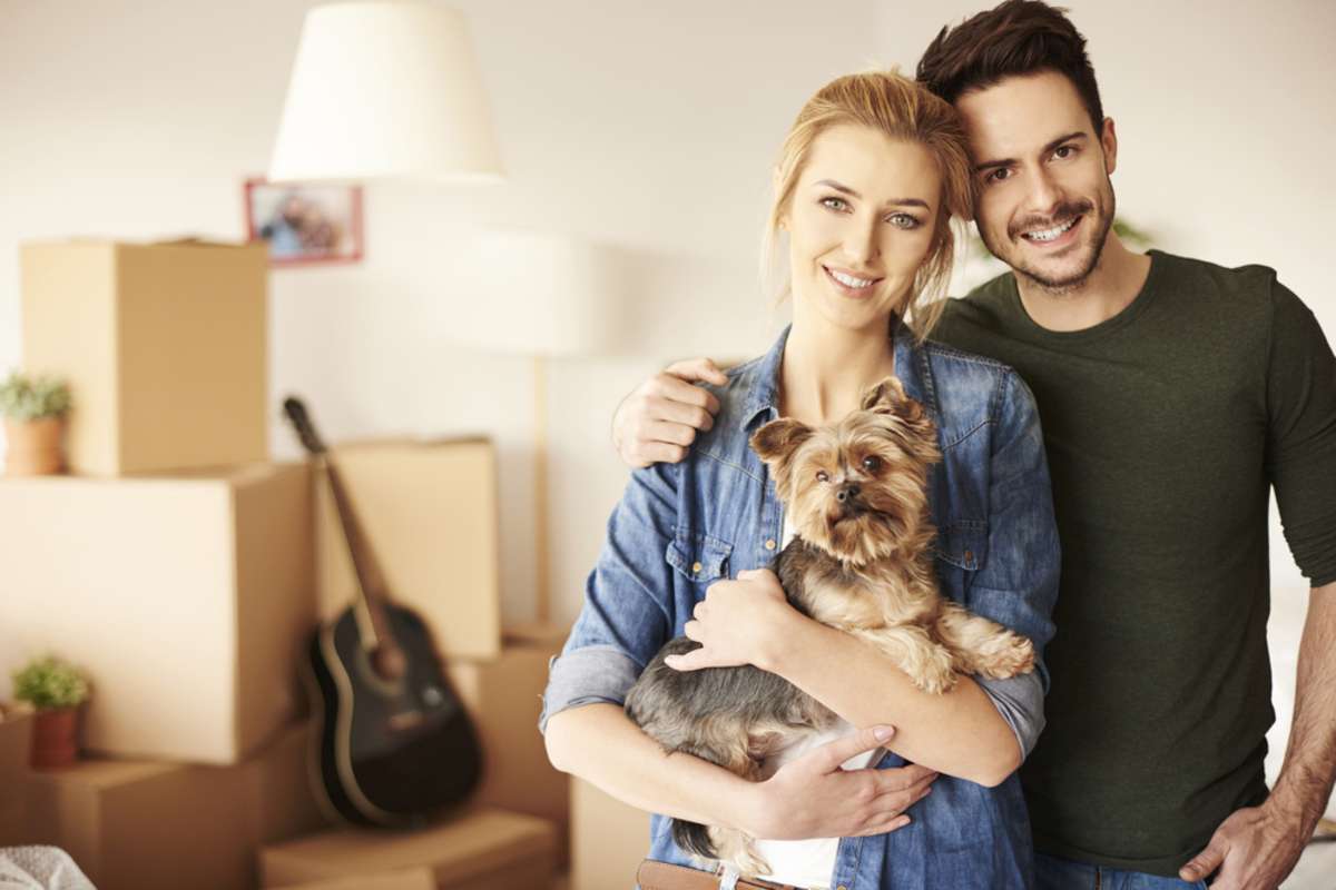 Couple with dog and moving boxes in home, best property management companies Charleston, SC, concept