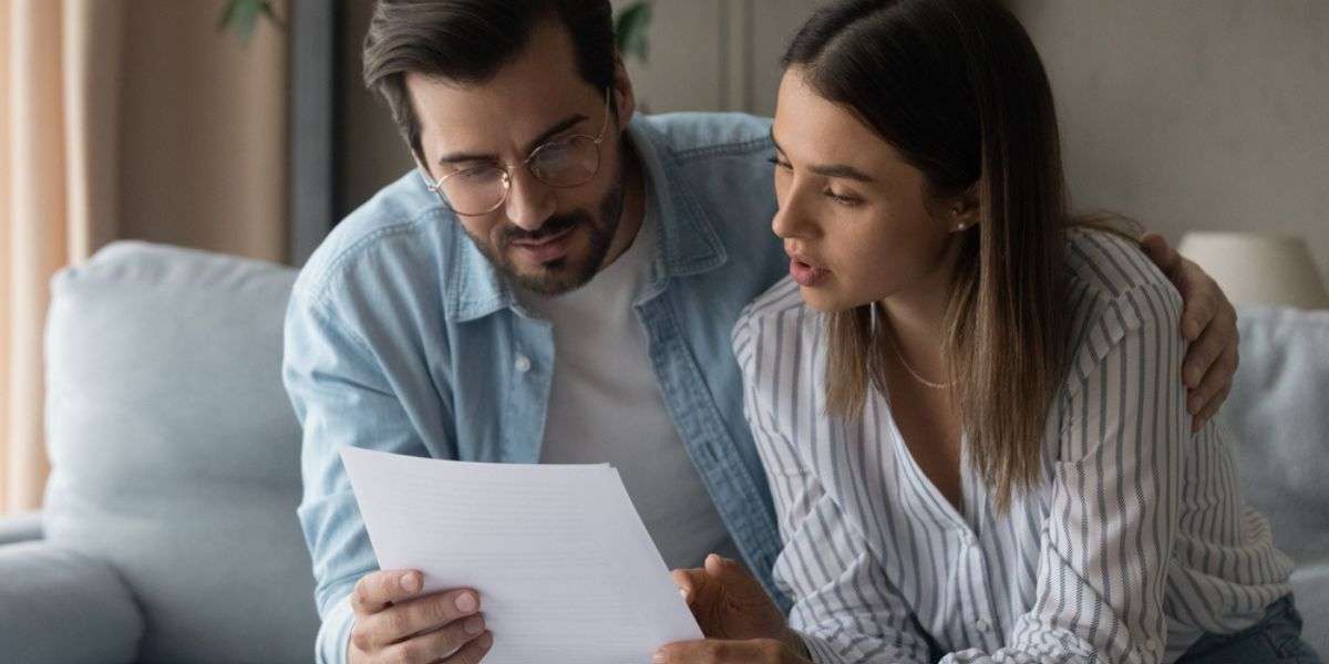 Young couple reviewing documents in a home, Charleston property managers concept