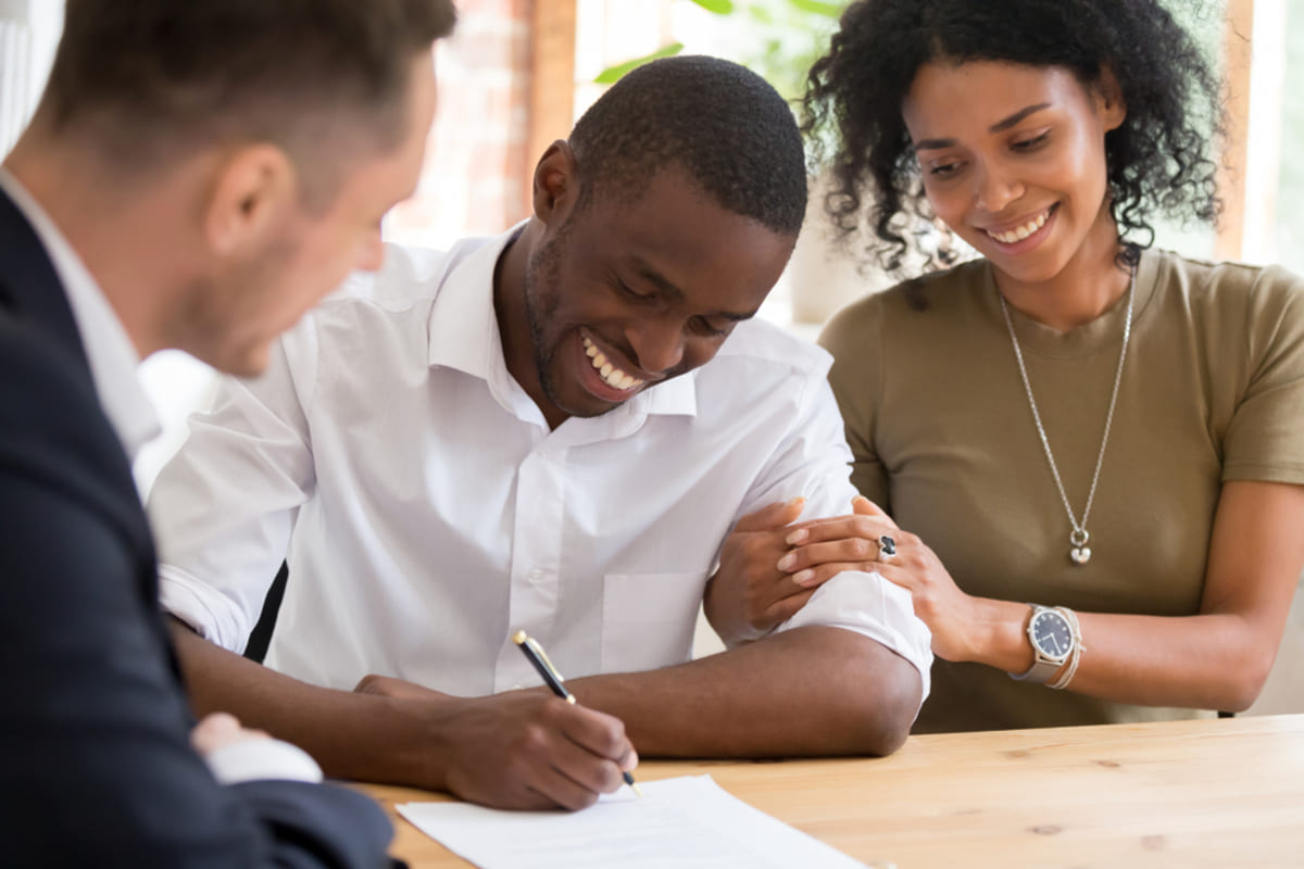 A couple signing a leasing form for a property, tenant marketing concept