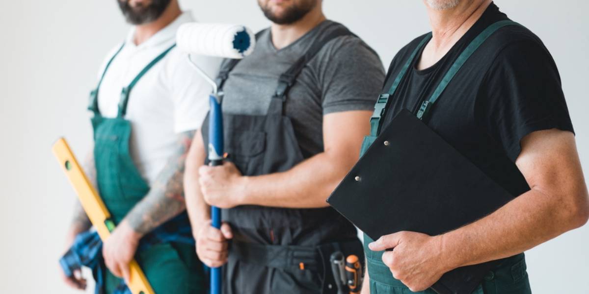 Crew of three professional builder wearing overalls standing