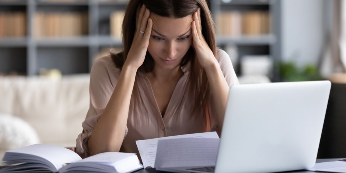 Stressed young woman holding head in hands