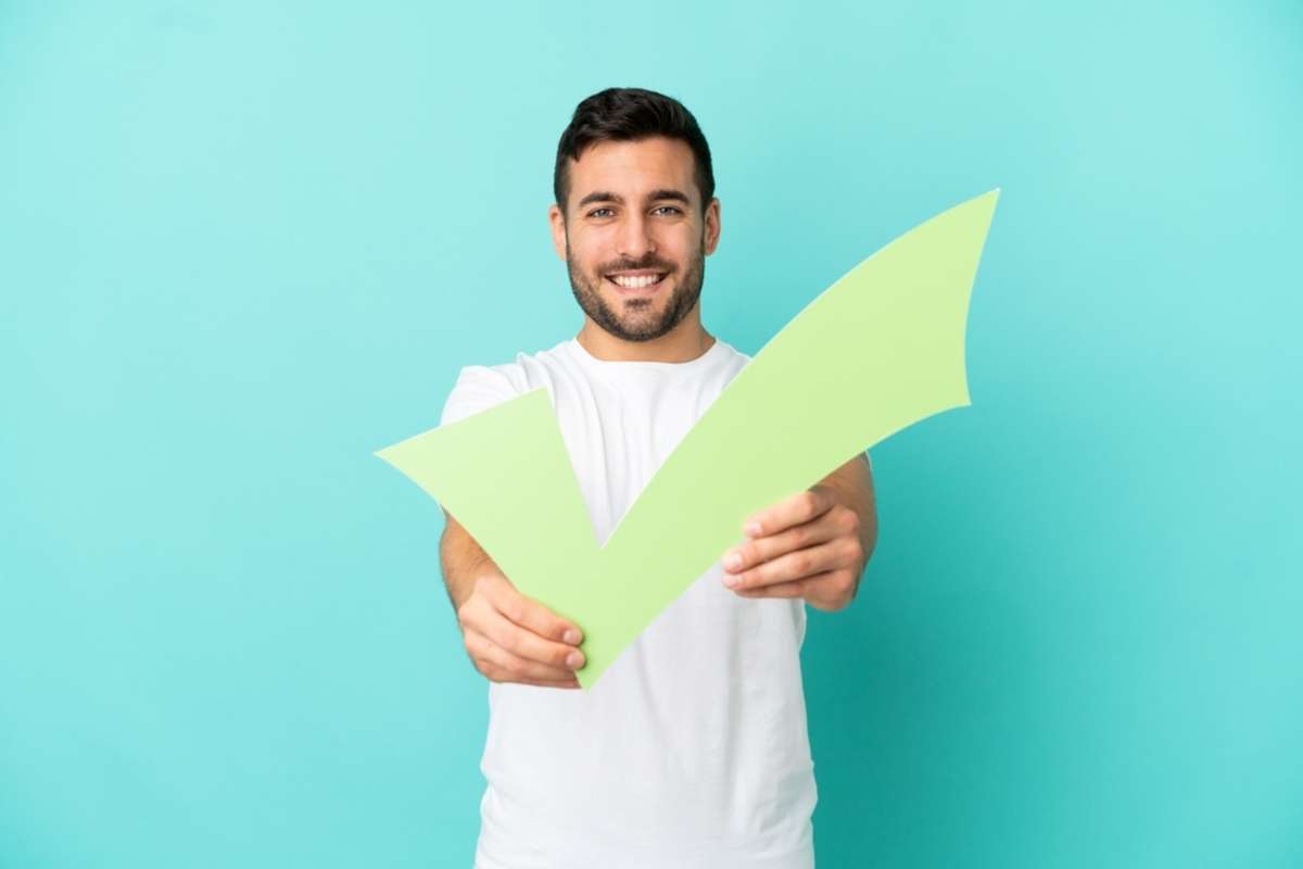 A man holds a checkmark for the signs of a good property management company