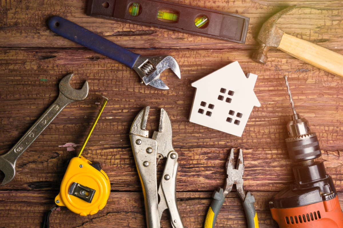 A wooden house with maintenance tools surrounding it