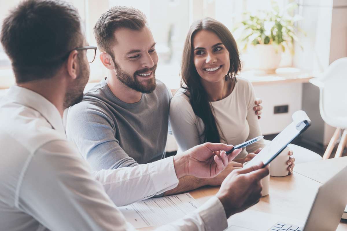 Businessman holding document, talking with a couple in home, property management services concept