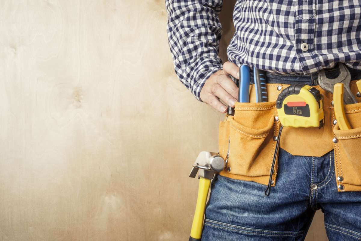Man wearing toolbelt with tools, should I rent out my home or sell it concept